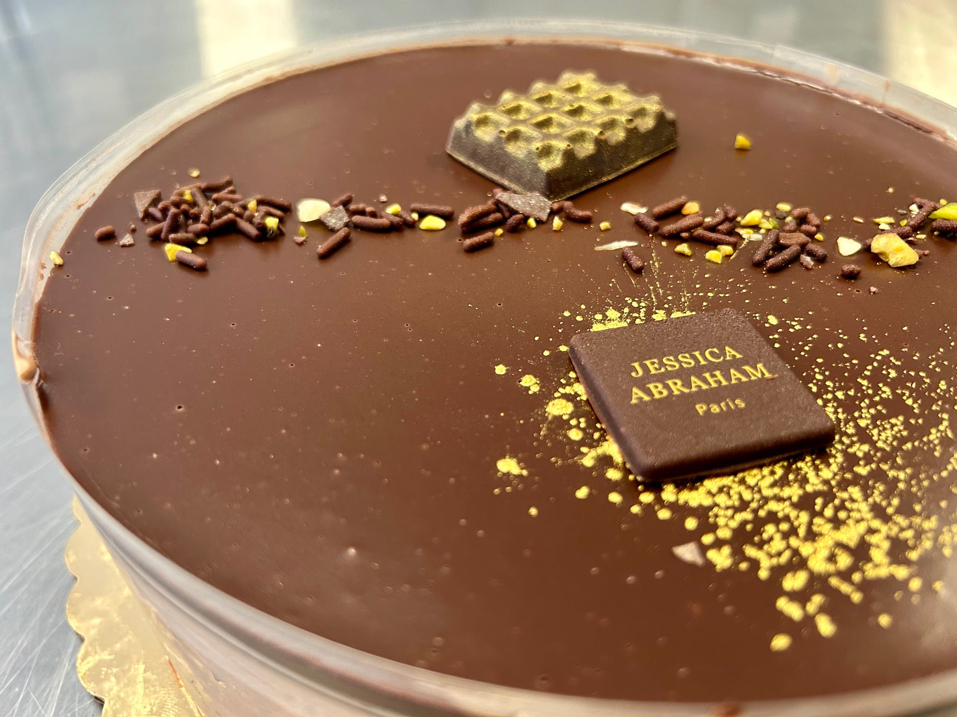 Chocolate cake with decorative elements and 'Jessica Abraham Paris' branding.