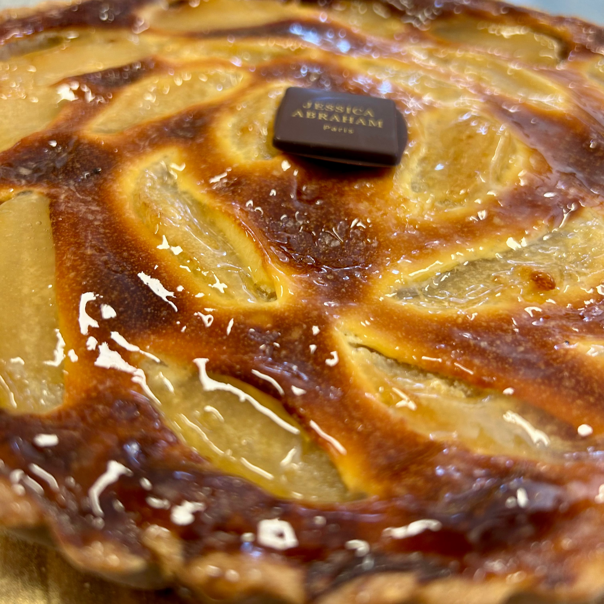 pear and chocolate tarte with a 'Jessica Abraham' label on a reflective surface