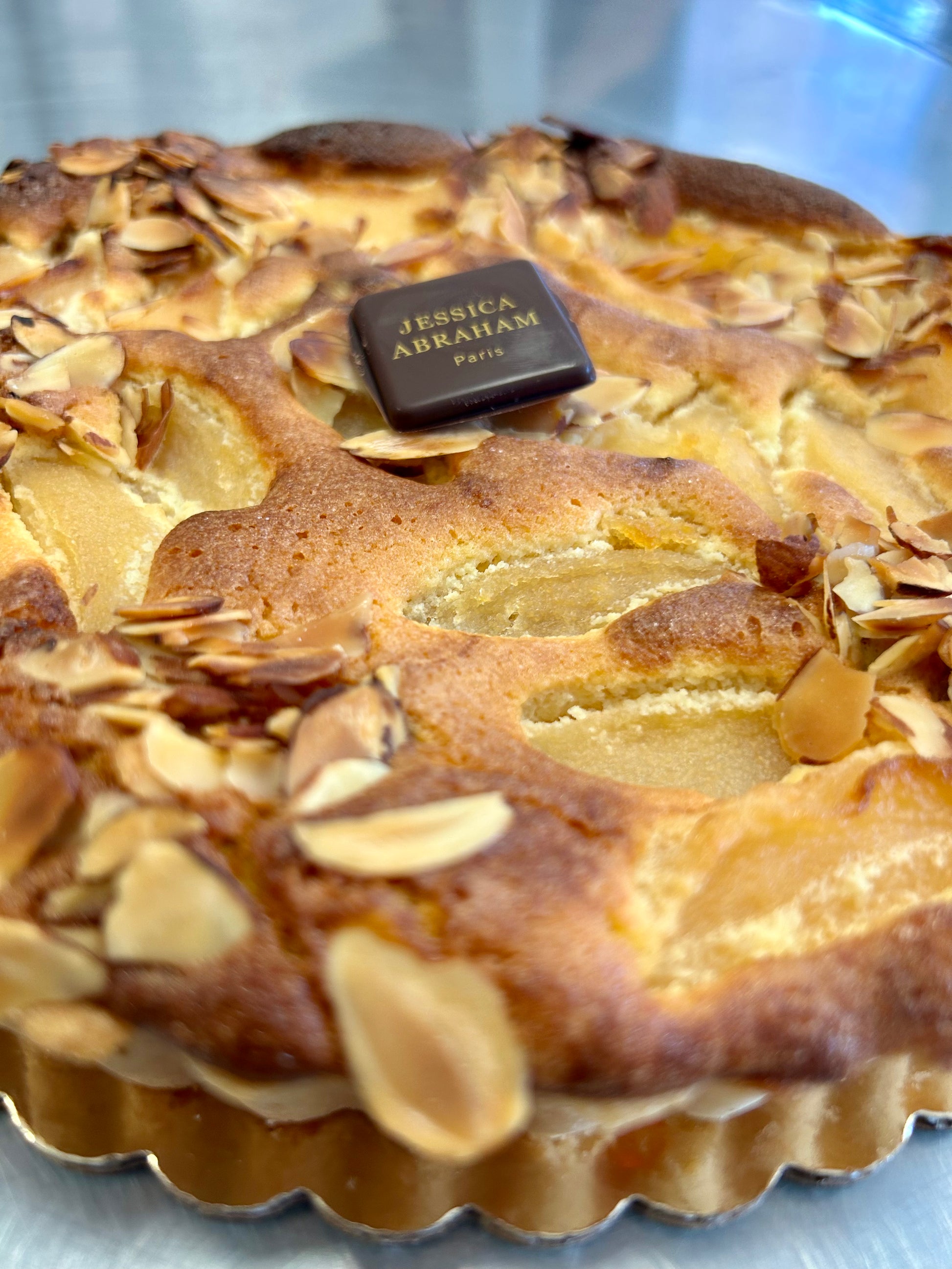 Pastry with almonds and a chocolate bar on top, branded 'Jessica Abraham'.
