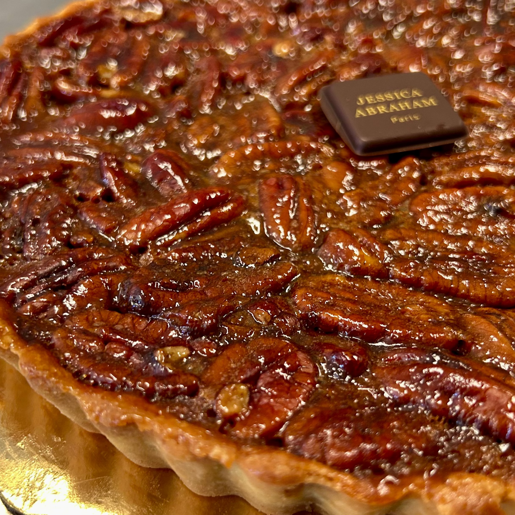 Pecan pie with a chocolate bar on top branded 'jessica abraham'